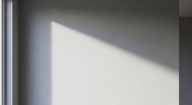 Düz bir duvar boyunca parlak ışık ve keskin çapraz gölgeli minimum iç mekan