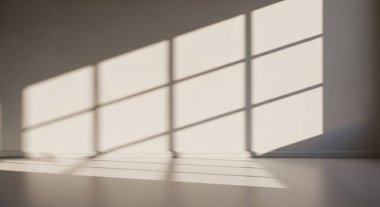 Bright morning light streams through large windows creating geometric shadows on a clean empty floor
