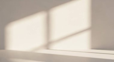 Yumuşak doğal ışığın pencereden aktığı, hafif bir yüzeyde nazik geometrik şekiller oluşturduğu minimalist bir iç mekan..