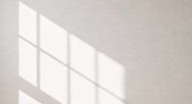 Yumuşak sabah ışığı pencerelerden akar beyaz bir duvarda yumuşak gölgeler yaratır.