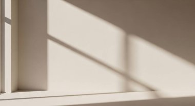 Minimal interior scene showing soft sunlight filtering through a window and casting geometric shadows on a painted wall.
