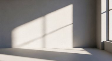 Sıcak güneş ışığını gösteren sakin bir sahne çıplak bir duvar ve zemin boyunca uzun dikdörtgen gölgeler oluşturuyor..