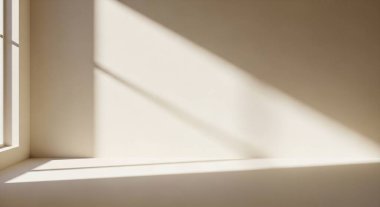 A quiet sunlit interior with angled shadows across a clean wall and floor, creating a calm and minimalist scene.