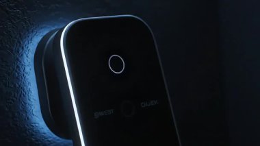 Parmak izi taraması, zaman göstergesi ve dijital arayüzü olan modern bir biyometrik erişim kontrol sistemi. Cihaz desenli bir duvara monte edilmiş..