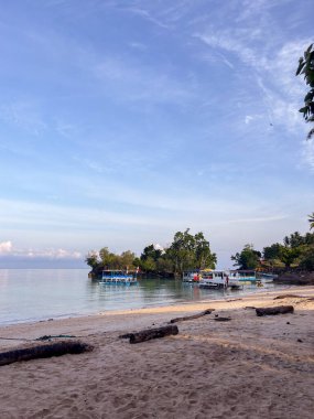 Bereketli adaların yakınında sakin bir mavi gökyüzünün altında serüven bekleyen teknelerle sakin tropikal mutluluğu keşfedin. Seyahat, tatil ve kaçış için mükemmel..