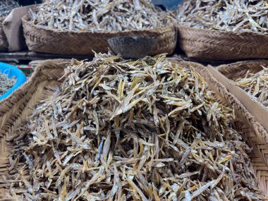 Canlı bir deniz ürünleri pazarında dokuma sepetlerinde lezzetli kurutulmuş ançüezler keşfedin. Mutfak projeleri ve geleneksel mutfağı sergilemek için mükemmel..