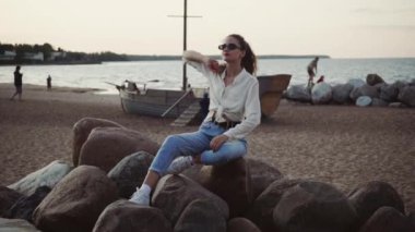 Genç beyaz kız Ladoga Gölü kıyısında plajda dinleniyor. Osinovetskiy deniz feneri