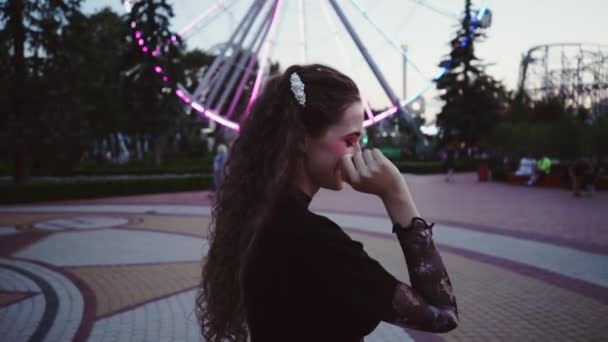 Saint Petersburg, Rusya 'daki eğlence parkında dönme dolabın önünde duran güzel genç kız. — Stok video
