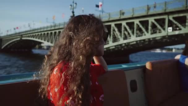 Kafkasyalı genç turist kız ya da kadın teknede oturuyor ve Saint-Petersburg şehrine bakıyor. Rusya, Ağır çekim. — Stok video