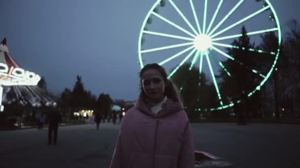 Beautiful young girl standing in front of Ferris wheel in activity amusement park in Saint Petersburg, Russia — Stock Video