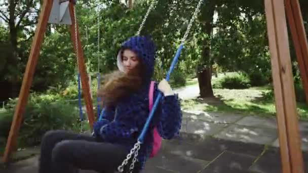 La jeune fille se balançant dans le parc à la froide journée d'automne — Video