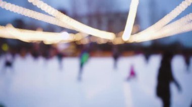Bulanık arkaplan. Sokakta buz pateni pisti. Yılbaşı ve Noel ışıkları parlıyor