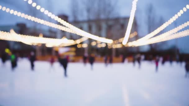 背景をぼかす。通りで冬のスケートリンク。新年とクリスマスの輝く光 — ストック動画