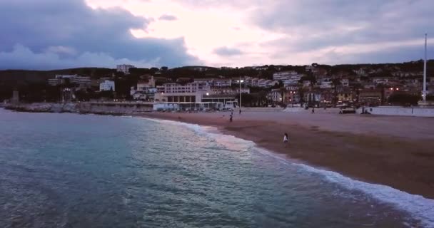 La ragazza cammina lungo la spiaggia. Costa Azzurra. Mare blu o oceano con onde. Cassis, Costa Azzurra, nel sud della Francia. Paesaggio drammatico. Vista aerea. Giornata nuvolosa e fredda. — Video Stock