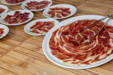 İnce dilimlenmiş jambon tabakları lezzetli bir aperatif oluşturuyor. Toplantının tadını çıkarmak ve paylaşmak için mükemmel.