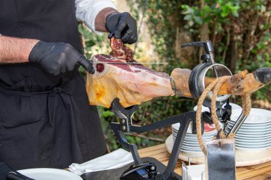 Profesyonel Jamn Serrano, açık hava mutfağı için yemek hazırlıyor.