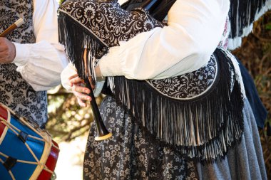 Geleneksel kıyafetler giyen, gayda çalan ve davul çalan halk müzisyenleri, enstrümanlarla kültür mirasını sergiliyorlar.