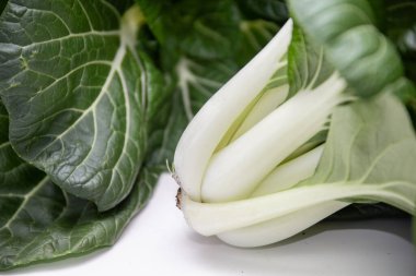 Bok choy kökleri ve yaprakları taze, yeşil dokuları gösteriyor, sağlıklı besin ve doğal ürünü temsil ediyor.