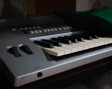 Beyaz ve siyah tuşlu eski bir elektronik klavyenin yakın plan fotoğrafı..