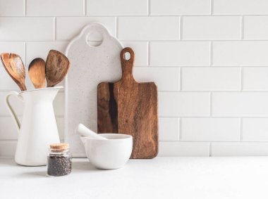 Beyaz mutfak arka planında beyaz mutfak aletleri beyaz tezgahta, metin için boş alan, ön görünüm