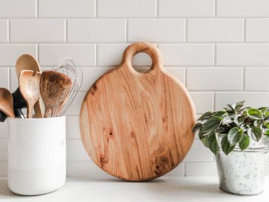 Beyaz mutfak arka planı mutfak aletleri ve tahta kesme tahtası beyaz tezgah, kopyalama alanı, ön görünüm