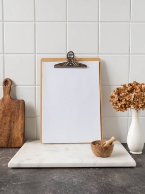 Mutfak malzemeleriyle beyaz mutfak arka planı ve metin, kopyalama alanı ve ön görünüm için boş kağıt sayfası olan pano.