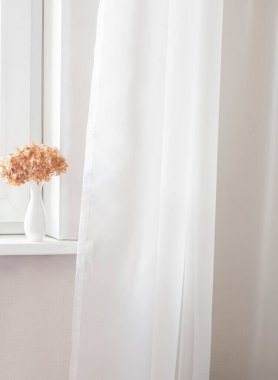 Pencere kenarında kırmızı ortanca çiçekli beyaz vazo ve beyaz tül. Çok az. Uzayı kopyala Ön görünüm