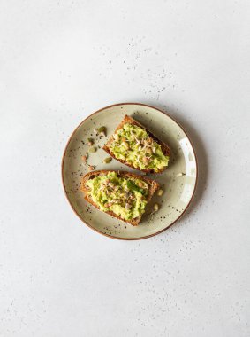 Sağlıklı avokado tostu, lahanalı ve yeşil tabakta çeşitli tohumlar. Üst Manzara. Boşluğu kopyala