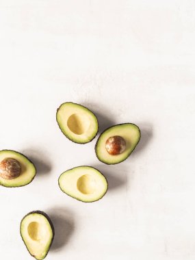 Beyaz desenli arka planda deri ve yarım kemikli olgun yeşil avokado.