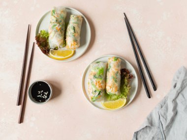 Vietnam börekleri salata, sos, yengeç, tabak üzerinde erişte ve pembe arka planda sosis. Üst Manzara. Boşluğu kopyala