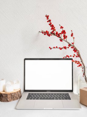 Modern Noel arkaplanı. Laptop boş ekran ve beyaz duvara karşı sezon dekorasyonu. Ön manzara. Boşluğu kopyala