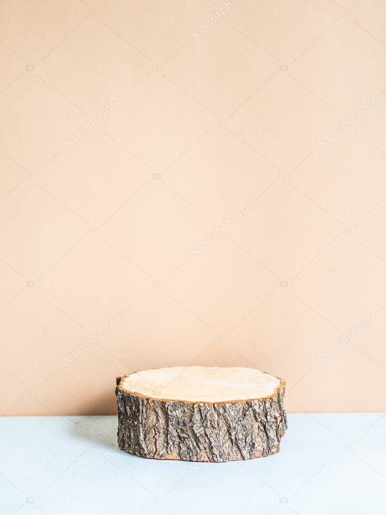 Creative trending minimal composition with natural wood podium on pastel beige background. copy space. Front view .Podium for the presentation of various products