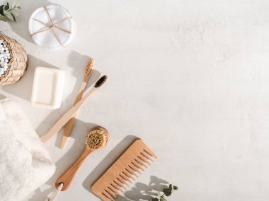 Çeşitli ekolojik eşyalar - diş fırçaları, saç fırçası, yeniden kullanılabilir pamuk pedleri beyaz arka planda beyaz havlu ve yüz fırçası. Üst Manzara. Boşluğu kopyala