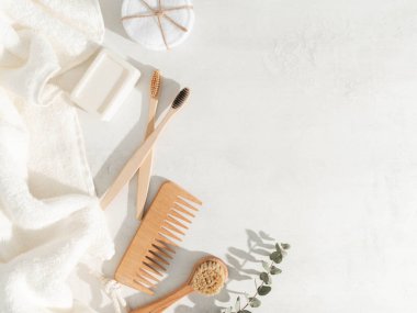 Çeşitli ekolojik eşyalar - diş fırçaları, saç fırçası, yeniden kullanılabilir pamuk pedleri beyaz arka planda beyaz havlu ve yüz fırçası. Üst Manzara. Boşluğu kopyala