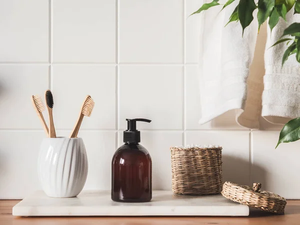 Banyoda banyo ürünleri, spa şampuanı, duş jeli, yanında havlu ve çeşitli aksesuarlarla sıvı sabun.