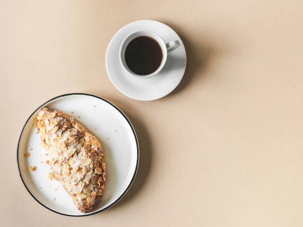 Ceașcă Cafea Croissant Proaspăt Placă Albă Fundal Bej Privire Sus — Fotografie, imagine de stoc