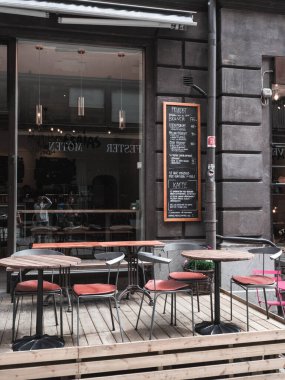 Stockholm 'de bir kafe. Masalar ve sandalyeler dışarıdaki tahta platformda..