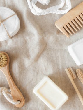 Zero waste care for women's skin. Soap, dry shampoo, cotton buds, toothbrushes, cobs on natural textile background. top view. Copy space