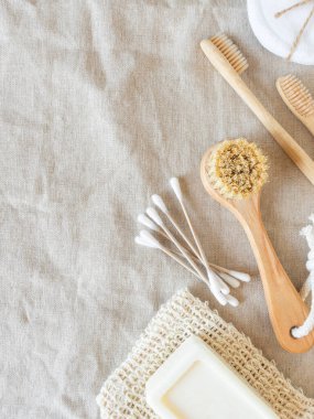 Zero waste care for women's skin. Soap, cotton buds, wood brush, toothbrushes on natural textile background. top view. Copy space