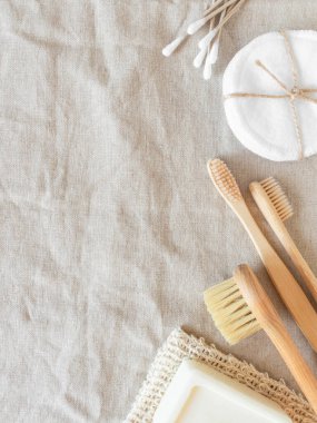 Zero waste care for women's skin. Soap, cotton buds, wood brush, toothbrushes on natural textile background. top view. Copy space