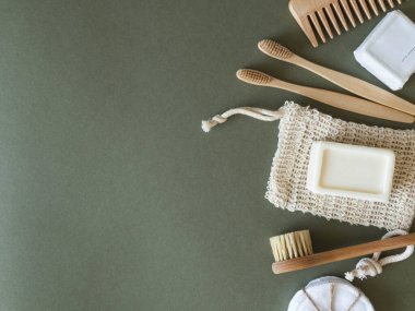 Kadın derisi için sıfır atık bakımı. Sabun, kuru şampuan, pamuk tomurcukları, diş fırçaları, yeşil arka planda koçanlar. Üst Manzara. Boşluğu kopyala