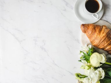 Düz kahve çerçevesi, çiçek buketi ve mermer arka planda kruvasan. Fransız kahvaltı konsepti. Üst Manzara. Boşluğu kopyala