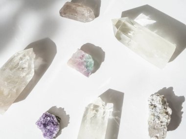 Güneş ışığının gölgeleriyle beyaz arkaplandaki mineral kristallerinin toplanması