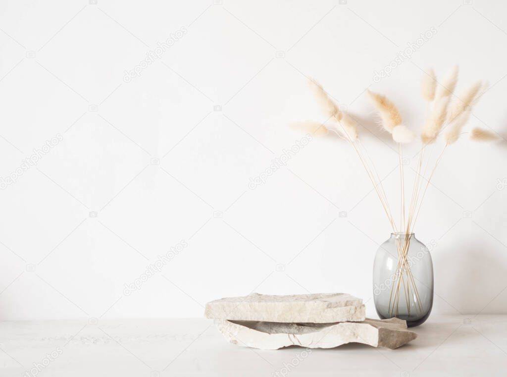 Grey natural stones podium on white background, platform for product display and dry branches in vase. Blank for mockup design. Front view. Copy space