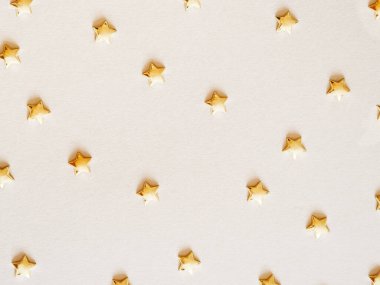Parti parlak dekorasyon deseni - bej arka planda konfeti şeklinde altın yıldızlar düz yatıyordu. Üst görünüm