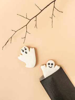 Zencefilli kurabiyeli en az Cadılar Bayramı kompozisyonu. Bej arka planda siyah kağıt torbaların hayaletleri. Cadılar Bayramı konsepti Üst Manzara. Boşluğu kopyala