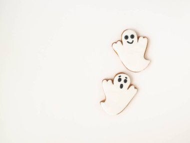 Beyaz arka planda hayaletler olan zencefilli kurabiyeli en az Cadılar Bayramı kompozisyonu. Cadılar Bayramı konsepti Üst Manzara. Boşluğu kopyala