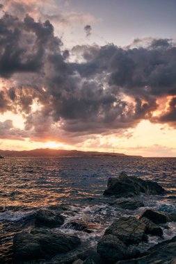 Tyrhenian Denizi üzerinde kara bulutlar ve İtalya 'nın güneyindeki Scilla, Calabria' dan Sicilya manzaralı dramatik bir gün batımı. Seyahat ve deniz manzarası arkaplanı.
