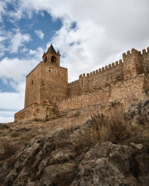 İspanya, Antequera 'daki tarihi ortaçağ kalesi, taş duvarlar ve bulutlu gökyüzü