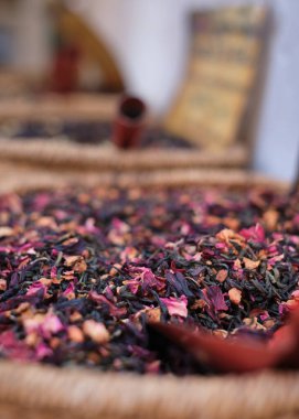 Yumuşak bitki çayı dokuma sepetinde amber çiçeği yapraklarıyla harmanlanır, yiyecek ve sağlık için yakın çekim dokusu kullanılır.